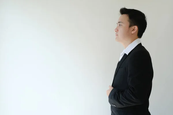 stock image Young Asian businessman standing and facing to his right side. Isolated white background.