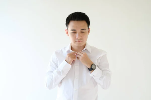 Young Asian Man Buttoning His White Shirt Isolated White Background Stock Image