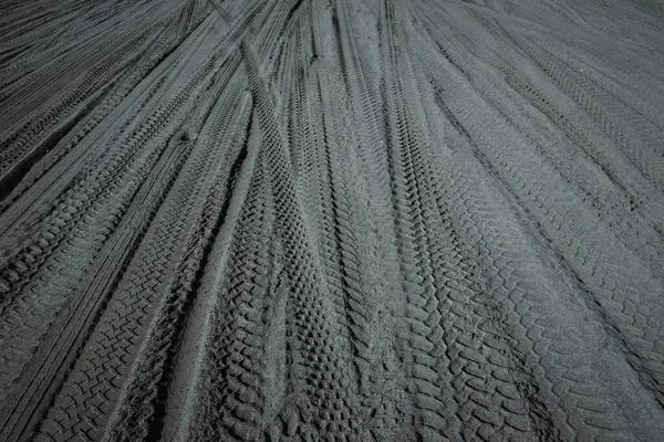 Off-road vehicle tracks on the black sand