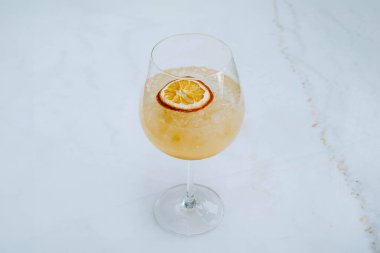 Buz Tropikal Sangria 'nın seçmeli odak noktası ya da beyaz mermer masadaki şarap kadehinde soda ile portakal kokteyli.