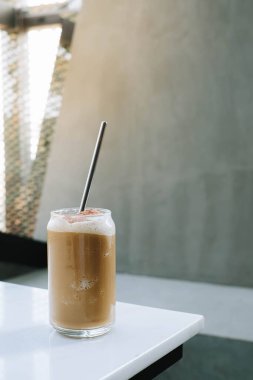 Üzerinde paslanmaz çelik pipet olan bir bardak buzlu kahvenin seçici odak noktası.