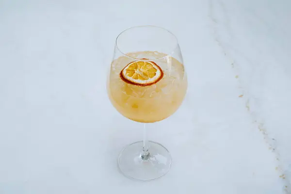 白い大理石のテーブルのワイングラスにソーダとアイストロピカルサングリアまたはオレンジカクテルの選択的な焦点ショット — ストック写真
