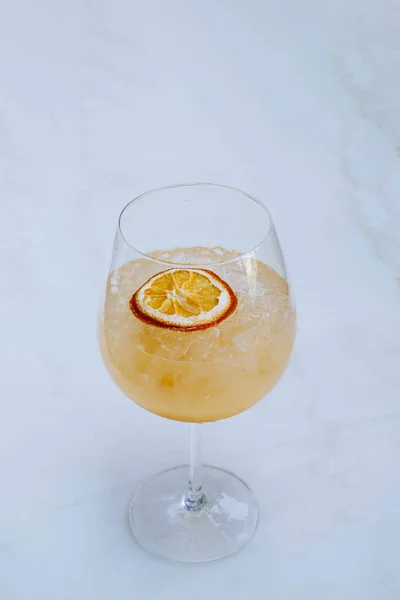 白い大理石のテーブルのワイン グラスでソーダが付いている氷熱帯サングリアまたはオレンジ カクテルの肖像画か縦および選択的な焦点ショット — ストック写真