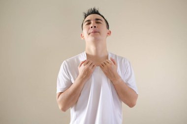 Genç bir Asyalı sıcak hava koşulları nedeniyle tişörtünü tutuyor.