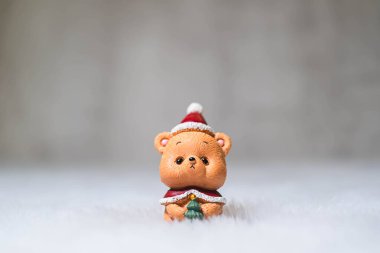 Küçük ve sevimli oyuncak ayıcık, Noel Baba şapkası takıyor ve hırka giyiyor. Kış ve Noel konsepti. Xmas dekorasyonu.