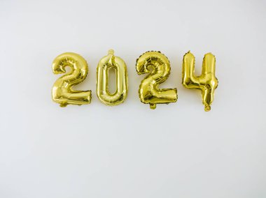 Beyaz duvarda asılı altın 2024 balon harfleri