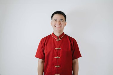 Geleneksel Çin kumaşı giyen Asyalı bir adamın ya da Cheongsam 'ın beyaz arka plandaki kameraya bakıp gülümsemesi. Gong Xi Fa Cai.
