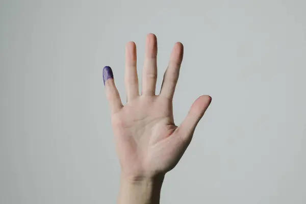 A hand with purple ink applied on little finger after pemilu or Indonesian presidential election