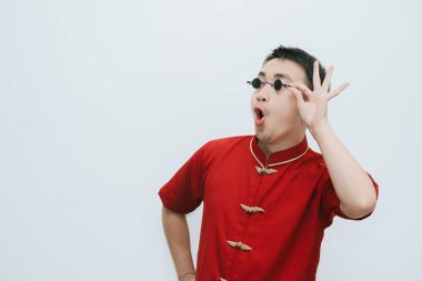 Cheongsam giyen Asyalı bir adam ve beyaz arka planda sağ tarafa bakarken siyah gözlüklü bir adam.