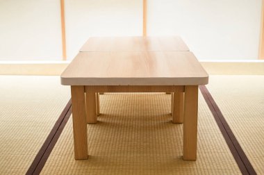 Zashiki 'deki ahşap masa ya da Japonya' da tatami döşeme kullanan odalara çapraz bacaklı oturma.