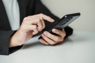 Akıllı telefon kullanan profesyonel bir adamın eli. Seçici odak.