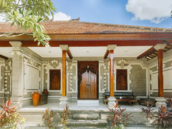 Ahşap ve taştan yapılmış dekoratif mimari tasarımı olan geleneksel bir Bali evi girişi.