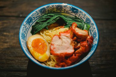 Char Siu 'lu Çin usulü kızarmış erişte, haşlanmış yumurta ve ahşap bir masada sebze. Kopitiam tarzında Kanton mutfağı. Üst görünüm açısı.