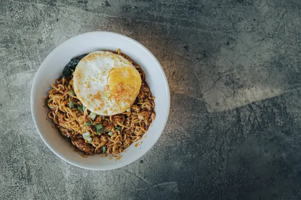 stock image Mie Bangladesh with boiled egg and some vegetables made from instant noodles originate from Medan or Aceh. Typical Southeast Asian food. Flat lay or top view angle with the object on the left.