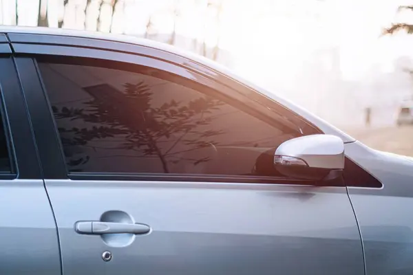 Renkli pencereli bir araba kırmızımsı güneş ışığını ve bokeh arkaplanını yansıtır