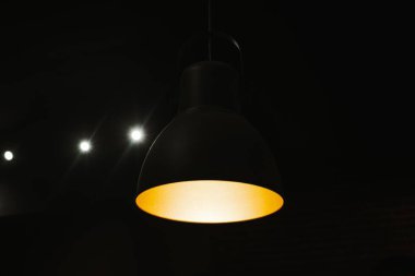 İçi siyah renkli, sıcak tavan lambası. Minimalist ve karamsar iç atmosfer.
