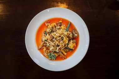 Hawker usulü istiridye omleti, kızarmış istiridye, sahanda yumurta, fasulye filizi ve biber soslu sebze içeren düz bir tabak.