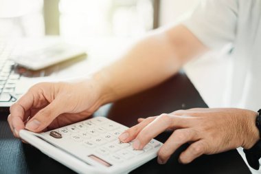 Kişisel finansman, bütçe ya da muhasebe hesaplarını hesaplamak için hesap makinesini kullanarak adamın elini kapat, bütçe yönetimi, aylık harcamalar, bokeh geçmişi olan finansal planlama