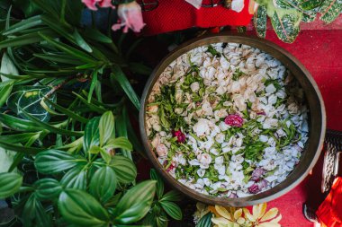 Cava düğün töreninde kullanılan geleneksel kil kasede su bulunan çiçek yaprakları. Adı Siraman.