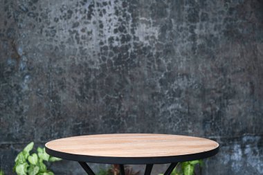 Yuvarlak tahta masa, beton arka planda siyah bacaklar. Ürün gösterimi için uygun, sahne.
