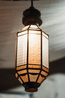 Buzlu cam ve bokeh arka planlı sıcak, klasik bir Arap feneri.