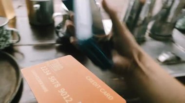 Bir EDC makinesinde kredi kartı işlemi yapan bir satıcının POV görüntüsünü kapat