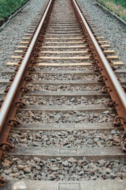 Yan tarafındaki yeşil yapraklarla birlikte uzaktaki eski bir demiryolu hattını kapatın.