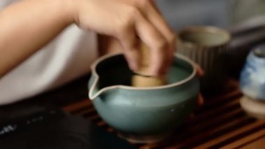 Geleneksel eşleşmeyi hazırlayan elin yakın çekimi: ölçüm tozu, bambu kovalamaca ile çırpma, seramik kasede çırpma çırpma. Çay seremonisi, farkındalık, Zen kültürü veya sağlıklı bir içecek için ideal..