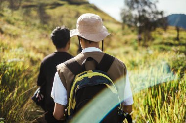 İki Güneydoğu Asyalı Bromo Dağı, Doğu Java, Endonezya 'da, dar bir dağ yolunda gün ışığında günlük giysiler ve sırt çantaları giyerek yürüyorlar..