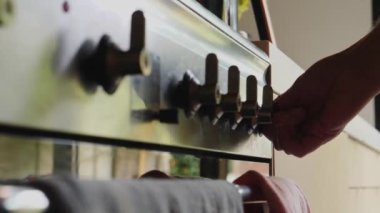 Erkek elinin mutfaktaki ocakta gaz düğmesini tutuşturduğu seçmeli odak noktası