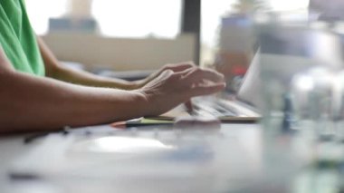 Evde çalışan ve dizüstü bilgisayarda yazan bir kadın.