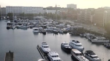 Rıhtımda insanlar rıhtımda yürürken yelkenli ve motorlu tekneler.