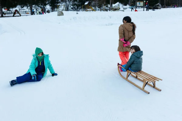 Elder Girl Pulling Smaller Girl Wooden Sled Snow Hill Other — Φωτογραφία Αρχείου