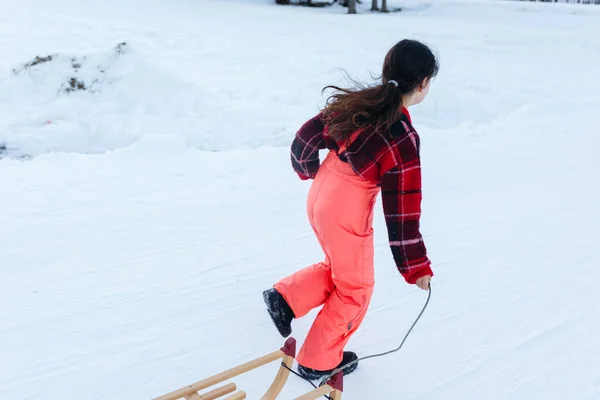 Dívka Červeném Svetru Oranžové Lyžařské Kalhoty Běží Pryč Dřevěnými Saněmi — Stock fotografie