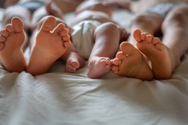 Feet Two Elder Siblings Newborn Baby Bed Home — Stock Photo, Image