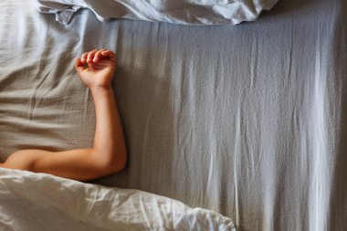 upper view on sleeping child arm on the bed