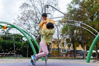 Oyun sahasında birlikte oynayan iki kız.