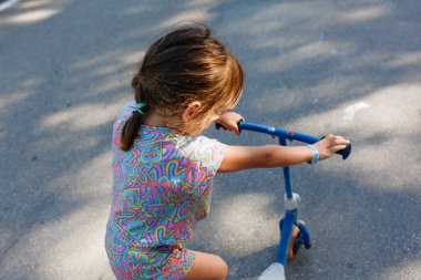 Güneşli bir günde motosikletli küçük bir çocuğun arkadan görünüşü