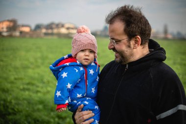 Babamın kucağında küçük bir kızıyla dışarıda oturduğu portresi.