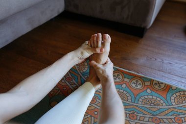 Evde egzersiz yapan bir kadının yakın plan görüntüsü.