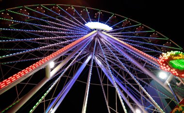 Geceleri renkli ışıkları olan dönme dolap. 