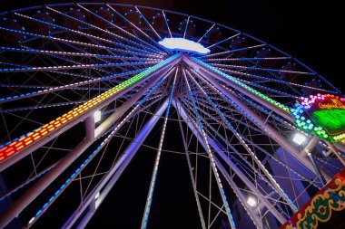 Geceleri renkli ışıkları olan dönme dolap. 
