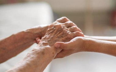 Yaşlı ve genç bir kadının elleri birlikte.