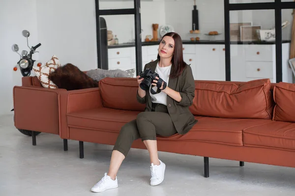 美しい若い女性が家でソファーに座っている カメラは女性の手の中にある 自撮り写真 美しく美しいプロの写真家の肖像 — ストック写真