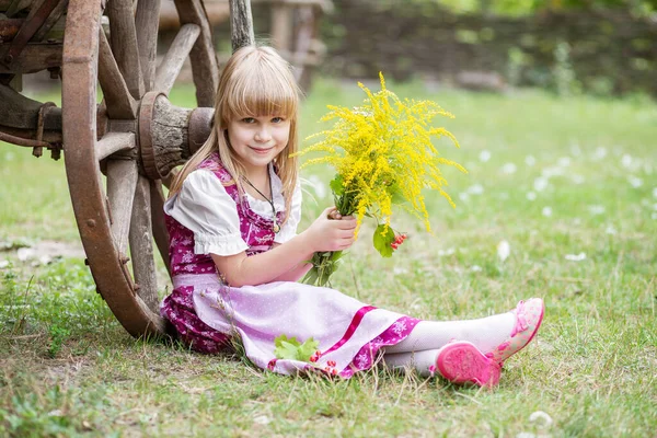 美丽的小女孩 身穿连衣裙 带着一束黄色的花朵 在村子里的大自然里 孩子在外面女孩在公园里散步 — 图库照片
