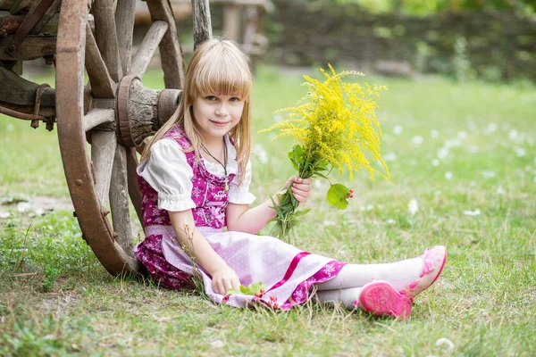 美丽的小女孩 身穿连衣裙 带着一束黄色的花朵 在村子里的大自然里 孩子在外面女孩在公园里散步 — 图库照片