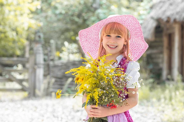 아름다운 소녀가 드레스를 노란색 꽃다발로 마을의 자연에 것이다 아이가 있어요 — 스톡 사진