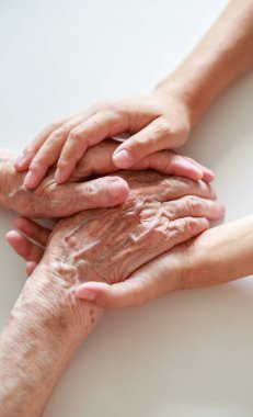 Eller yakın çekim. Yaşlı bir kadının elleri ve küçük bir çocuğun elleri birbirine dokunur. Nazikçe dokun. Yaşlı neslin bakımı. El sıkışarak sevginin ifadesi.