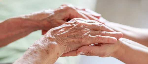 Close-up hands. The hands of an old woman and the hands of a small child touch each other. Gentle touch. Care of the elder generation. Expression of love through a handshake.