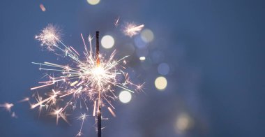Yeni yıl arkaplanındaki havai fişeklerden yapılmış güzel kıvılcımlar, mavi arka plan, Noel havası, parıltı, tatil geçmişi.